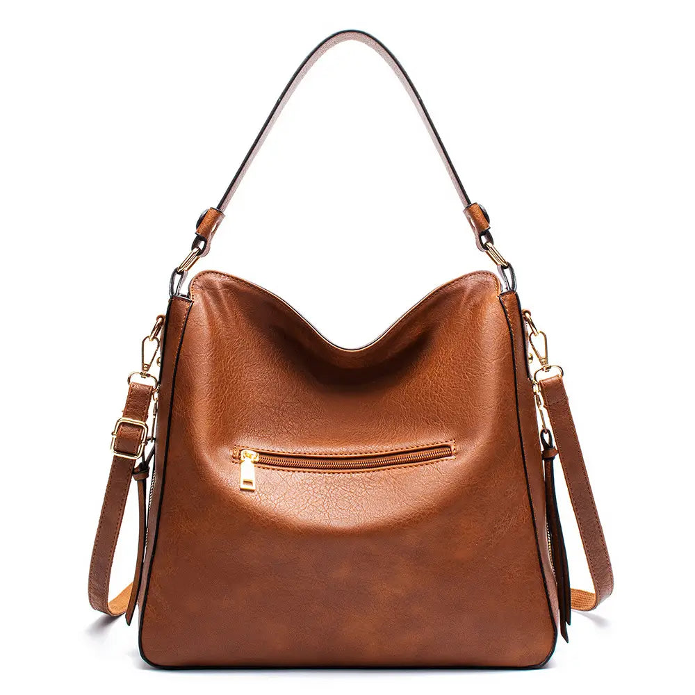 Premium brown leather hobo crossbody bag made of brown faux leather featuring a single shoulder strap and an adjustable crossbody strap with gold hardware.
