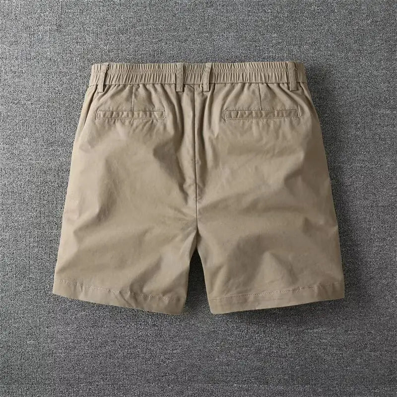Beige cotton men casual slim fit cargo shorts with an elastic waistband and two back pockets shown from the back side.