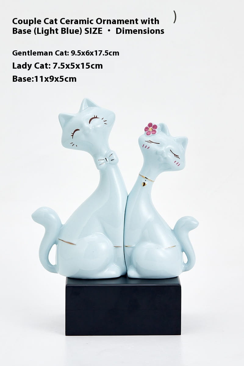 Light blue ceramic couple cat figurines with gold accents and a pink flower on the lady cat’s head for modern gold and white home decor.