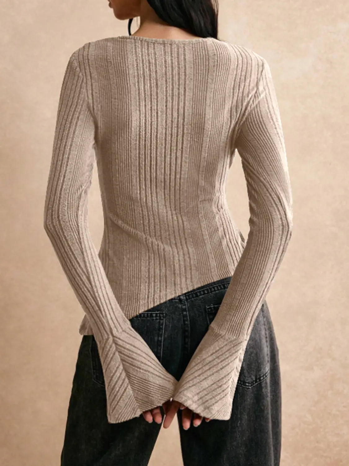 beige ribbed knit long-sleeve top with flared cuffs and a cutout detail on the front for a stylish casual look