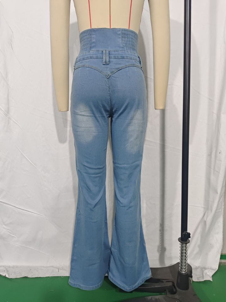 Jeans en denim bleu clair à taille haute évasée avec une ceinture élastique et des détails d’usure subtils.