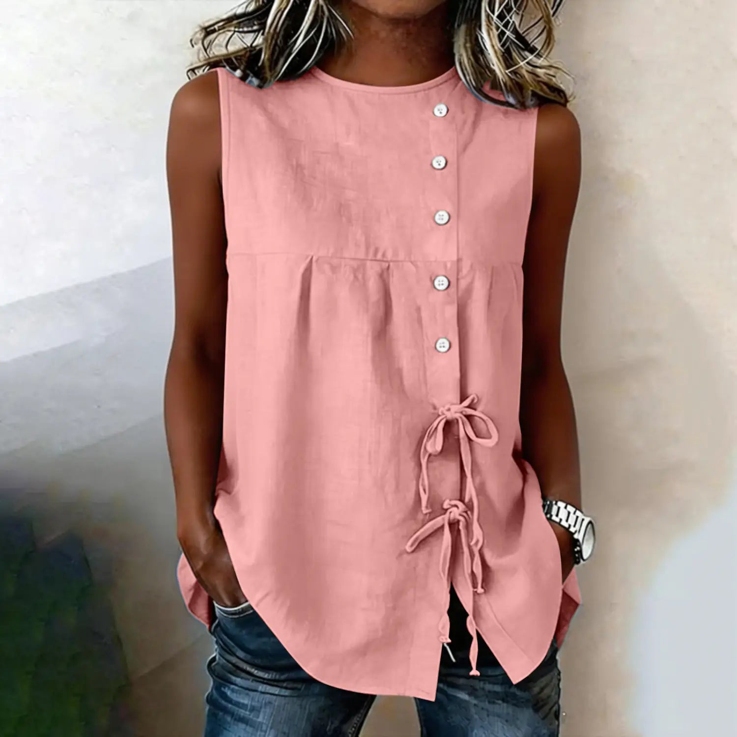 A soft pink sleeveless tie side button down blouse made of lightweight fabric perfect for casual wear.