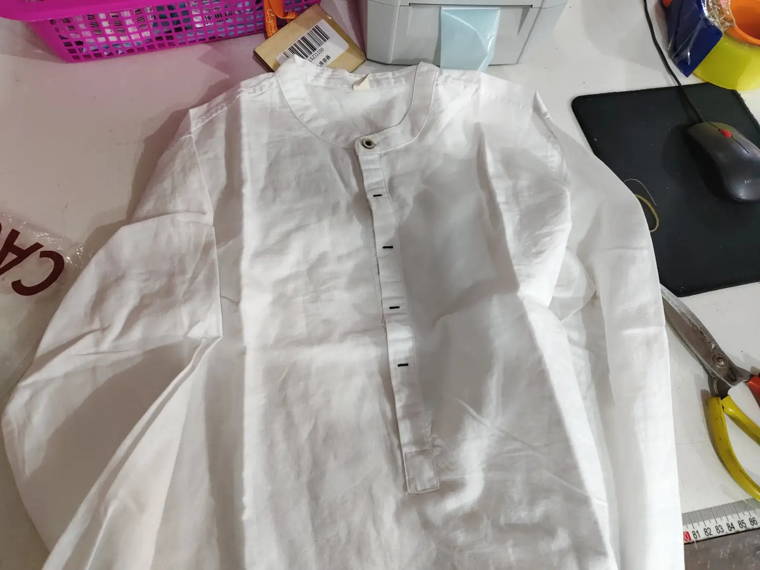 A crisp white men’s loose linen long sleeve shirt with a mandarin collar and button closure.