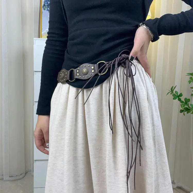 Brauner Gothic-Punk-Lederharness-Gurt mit Metallringen, dekorativer Metallschnalle und ausgefransten Kordelbindungen.