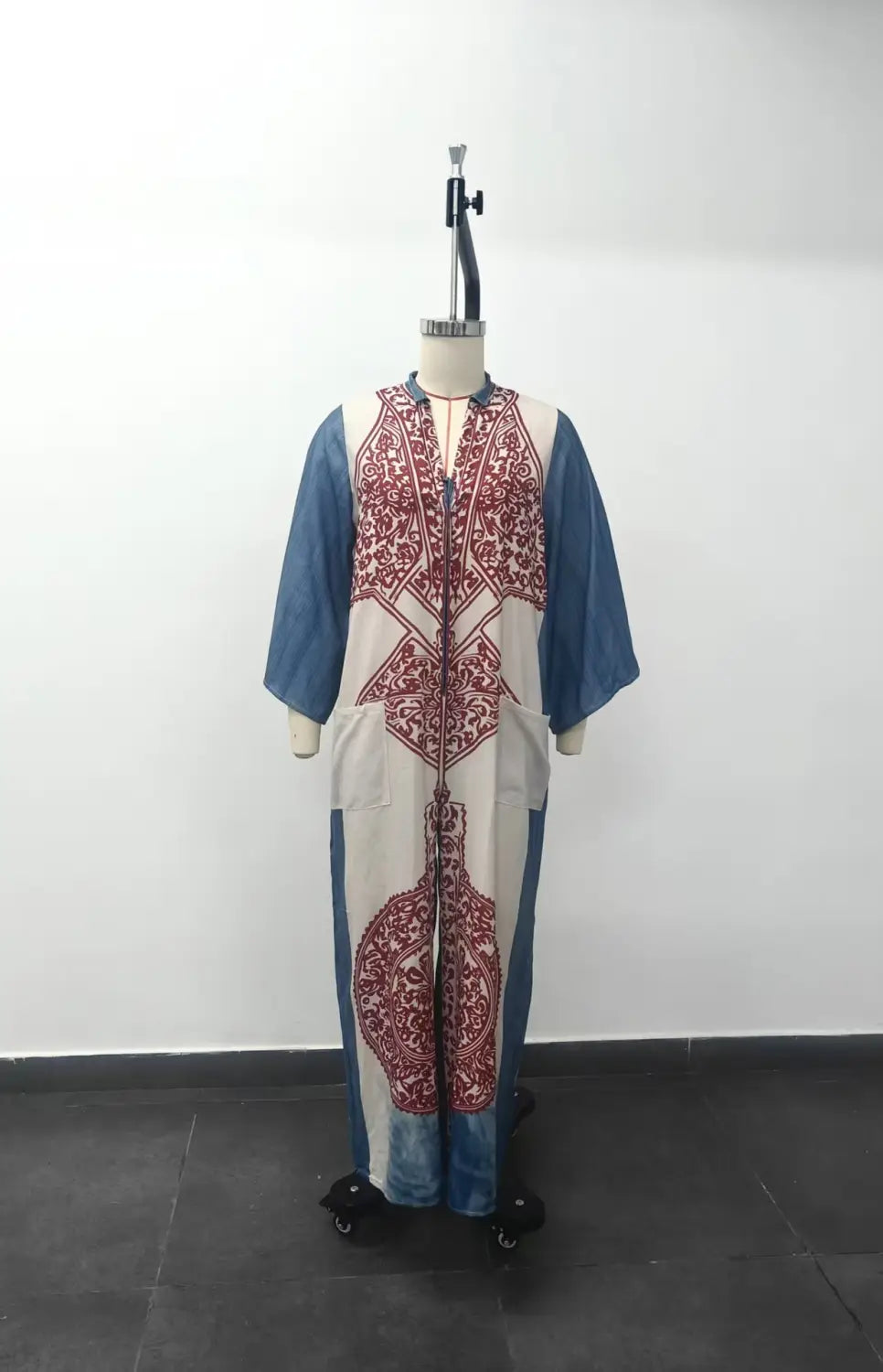 Pantalon bohémien à jambes larges imprimé associé à une robe caftan longue et fluide, crème et bleue, présentant des motifs brodés rouges complexes le long de l’avant et des manches.
