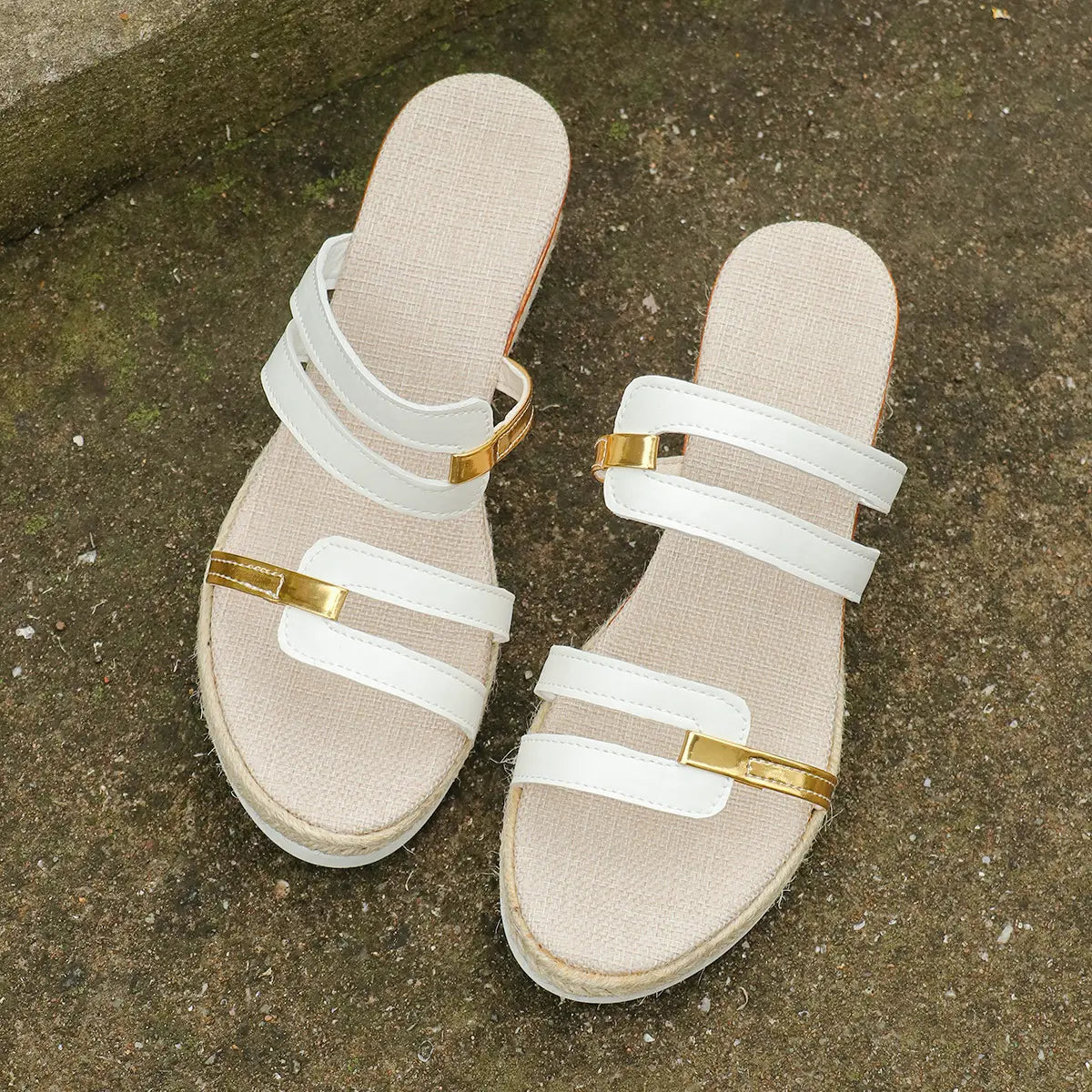 Wedge sandals with espadrille heel featuring white slide straps with gold-tone metal accents and a woven sole.
