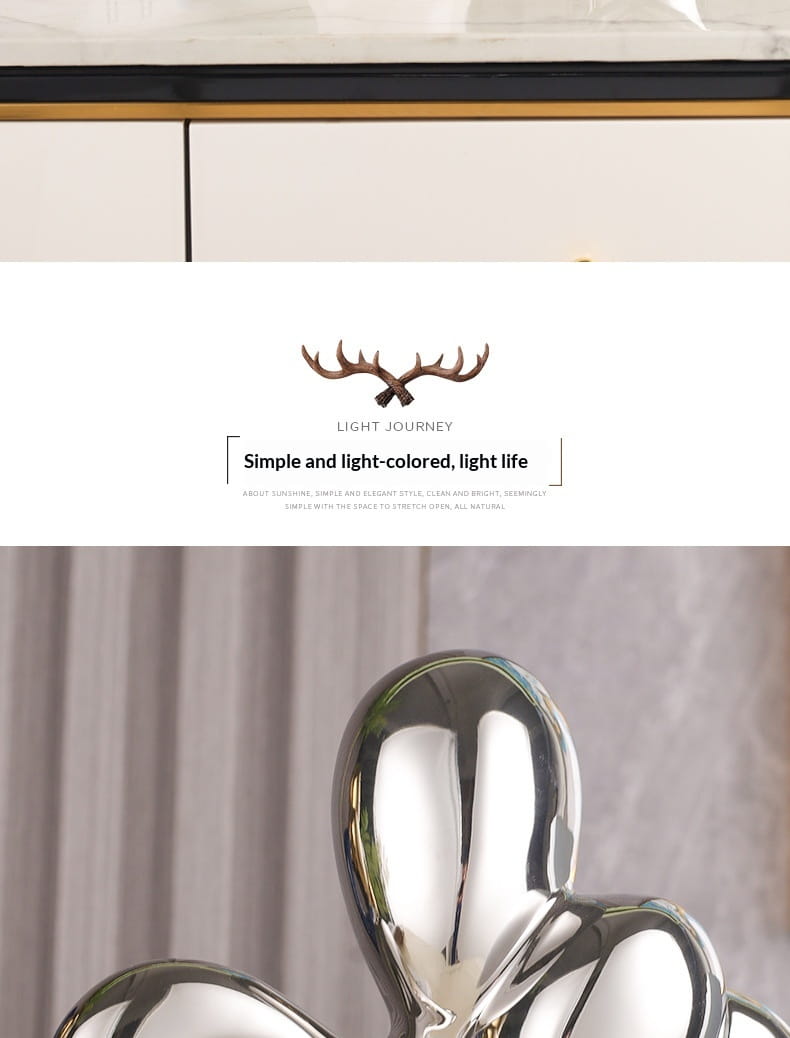 Shiny chrome-finished abstract heart ceramic figurine with smooth rounded contours resembling intertwined figures for modern home decor.