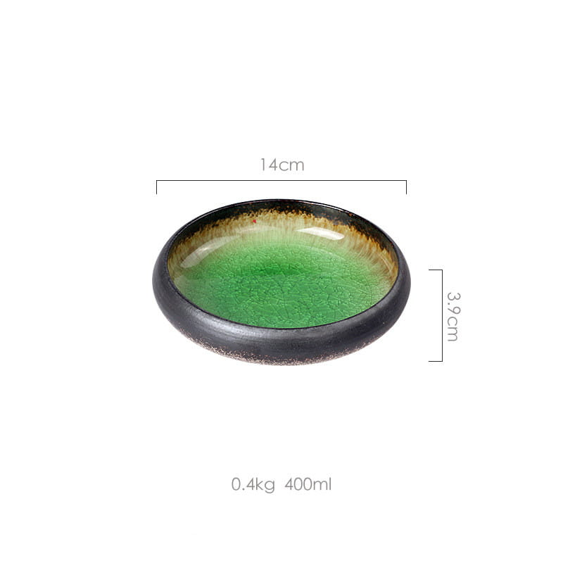 A handcrafted ceramic bowl kiln glazed with a glossy crackled green bone china interior and a dark speckled rim.