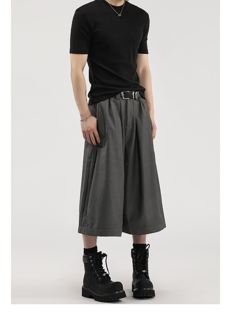 Short de costume pour hommes à jambes larges plissées gris foncé, coupe décontractée et plissés discrets réalisés dans un tissu léger.