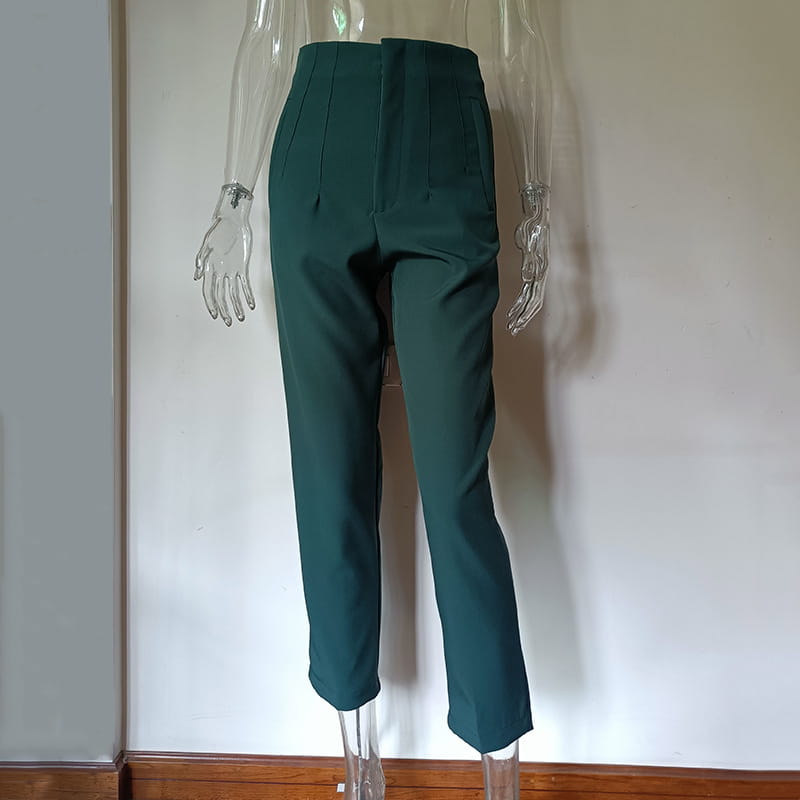 Pantalon taille haute à plis plats et jambes droites vert foncé, avec une coupe soignée et des plis sur l’avant.