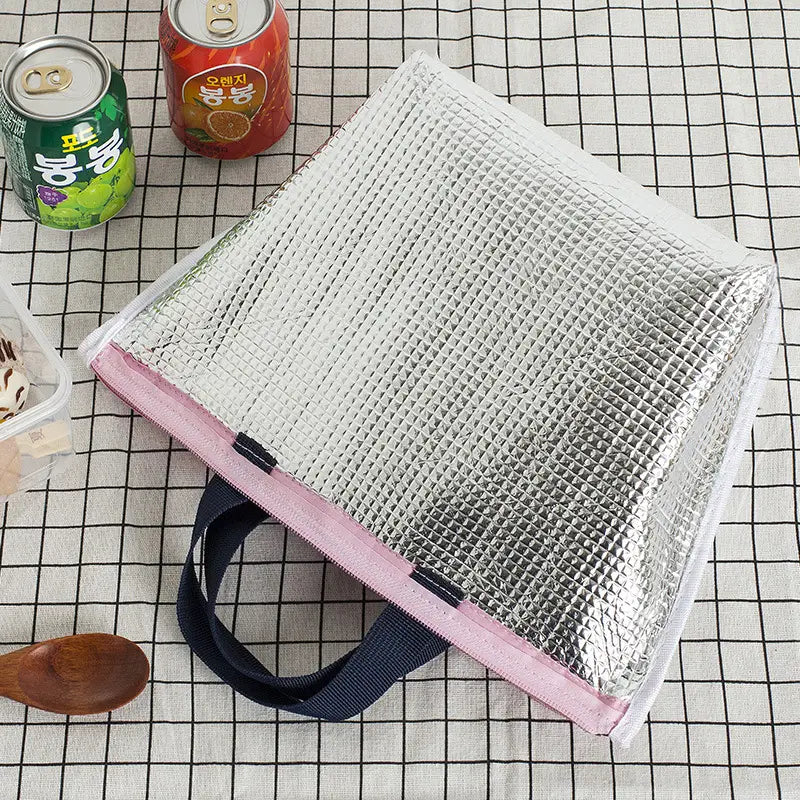 Silberne isolierte Oxford-Bento-Lunchbag mit Reißverschlussverschluss, mit pinkem Zierband und dunkelblauen Griffen.