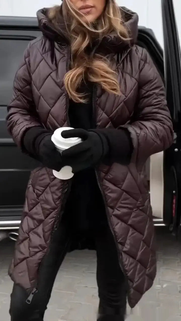 Ein langer brauner gesteppt wattierter Puffer-Mantel mit Kapuze für Damen mit schwarzen Zipper-Details, ausgelegt für Wärme und Stil.