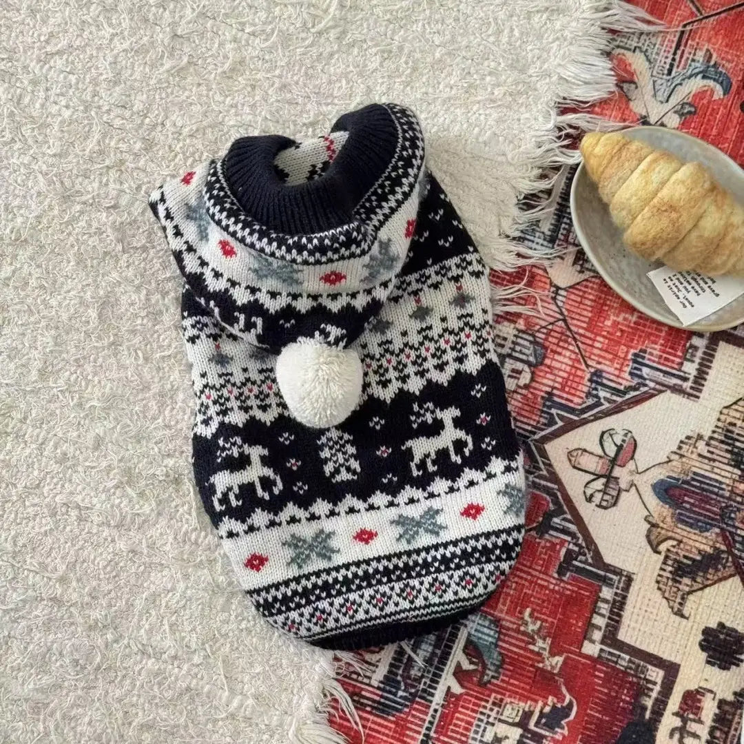 Pull en tricot pour chien noir et blanc, avec un motif festif de flocons de neige de rennes et des motifs de losanges rouges, comportant un pompon duveteux sur la capuche, pour des vêtements d’hiver chauds pour animaux de compagnie.