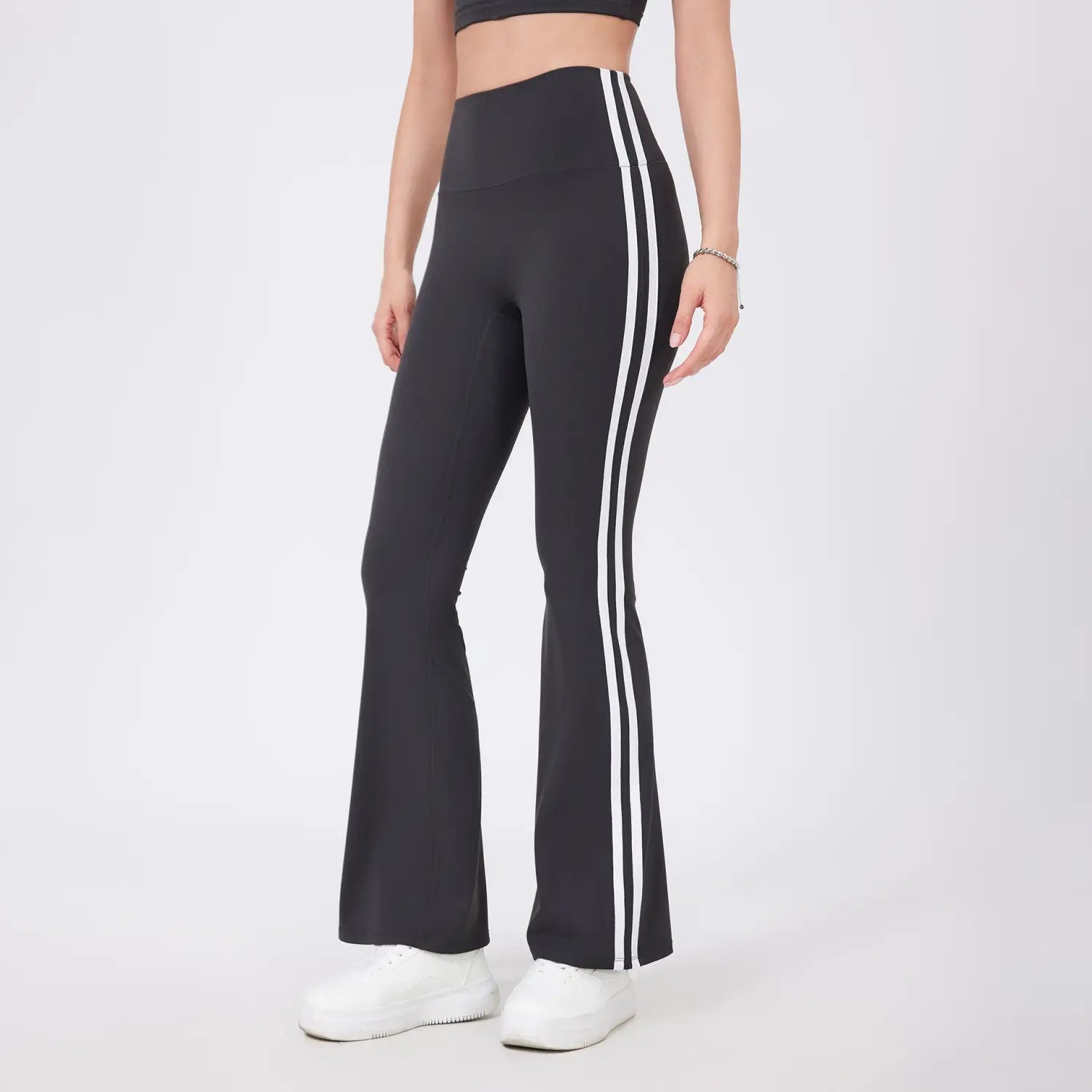 Leggings de yoga évasés taille haute noirs avec deux bandes latérales verticales blanches sur chaque jambe, présentés de face