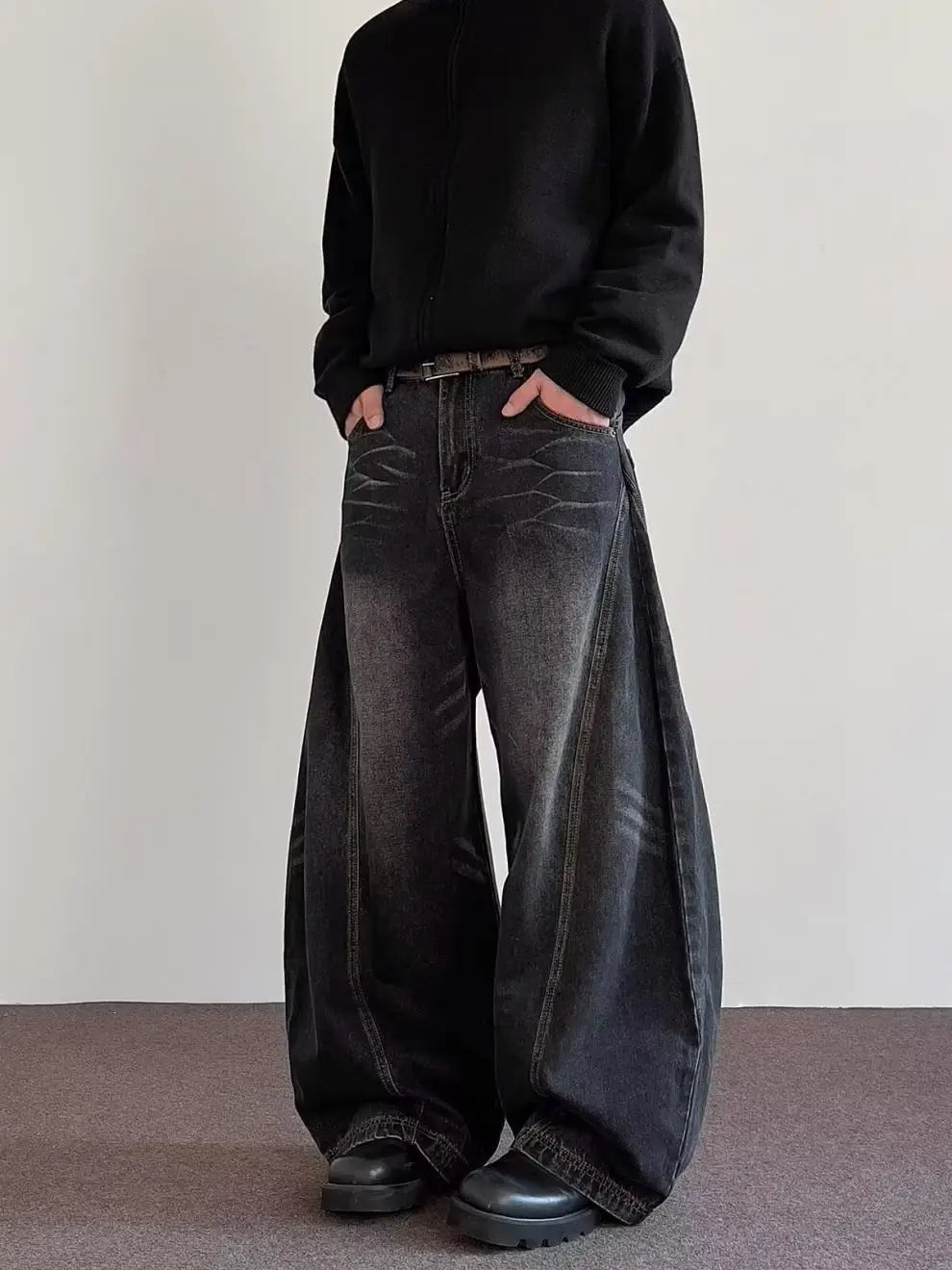 Men’s premium relaxed wide leg denim jeans in black with a faded distressed texture and visible stitching details.