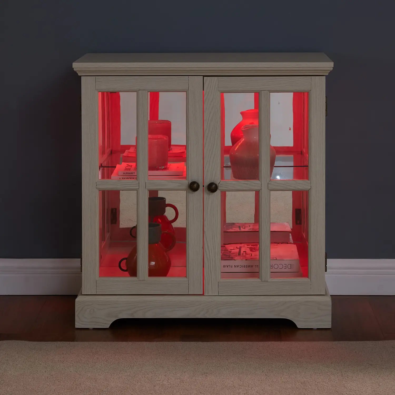 Led curio display cabinet with lattice doors in white wood finish featuring lighted glass doors showcasing red ceramic vases.