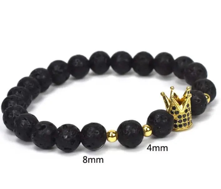 Black lava stone bracelet featuring a gold crown charm and small golden beads as part of the natural lapis lazuli and lava stone owl charm bracelet collection.