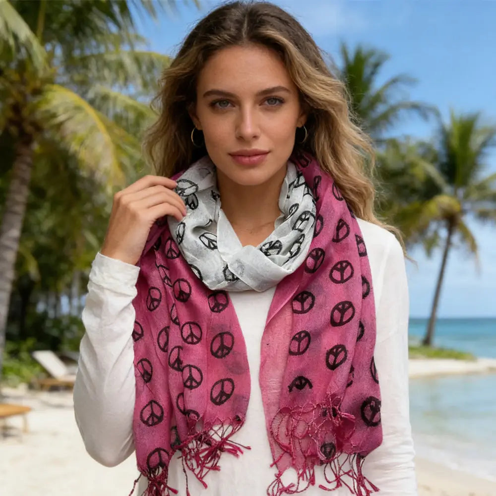 Ein lebhaftes fuchsiafarbenes Viskosetuch mit schwarzen Friedenssymboldrucken und ausgefransten Kanten, getragen als stilvolles Accessoire.