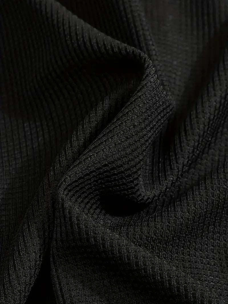 Black ribbed knit fabric with a textured woven pattern featured in a mens minimalist solid color sweatshirt jogger set.