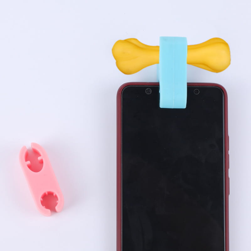 yellow and light blue silicone bone-shaped phone clip for pet selfies included in a dog toy set