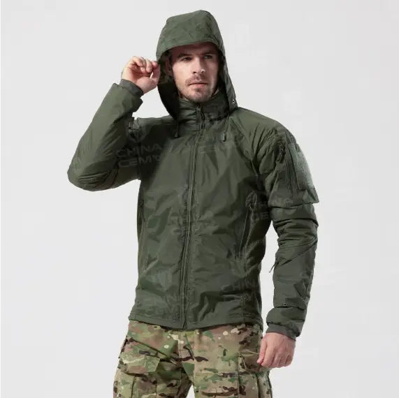 Veste tactique légère en coton softshell vert olive, avec panneaux d’épaule renforcés et poches zippées pour une durabilité et une fonctionnalité améliorées.