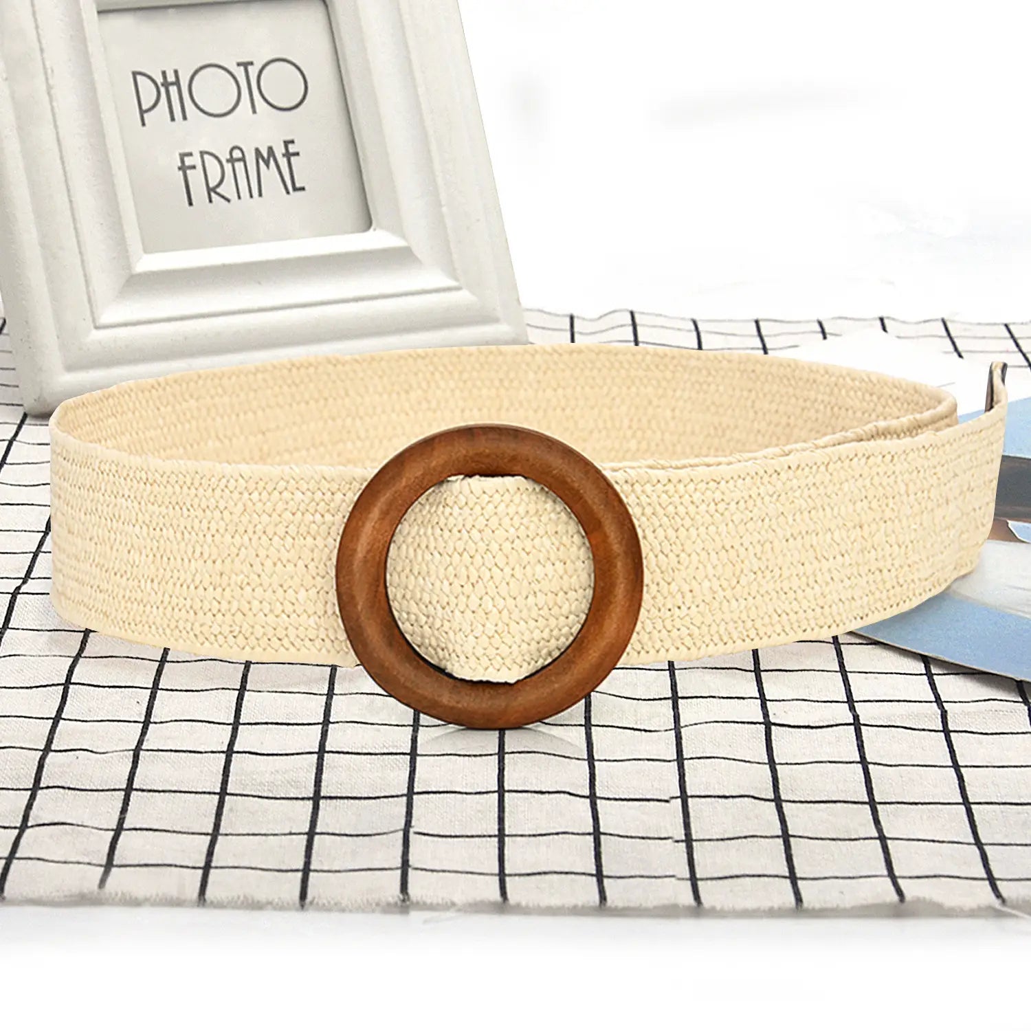 Beige woven elastic belt with a circular wooden buckle showcasing natural materials and flexible design.