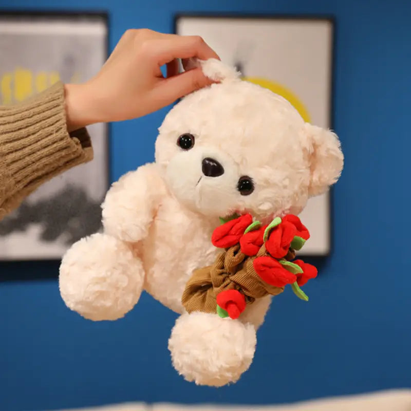 Ein weicher weißer Plüsch-Teddybär hält einen Strauß roter Stoffrosen, gebunden mit brauner Kordelband-Schleife; in einem Teddybär-Plüschtier mit Rosen, Valentinsgeschenk, 16–25 cm.