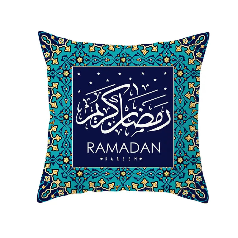 Funda de cojín de Ramadán Kareem azul y oro para linterna Eid, con un cojín turquesa y dorado con patrón, con un cuadrado central azul marino que muestra caligrafía árabe blanca que dice رمضان كريم, sobre la palabra ramadán kareem.