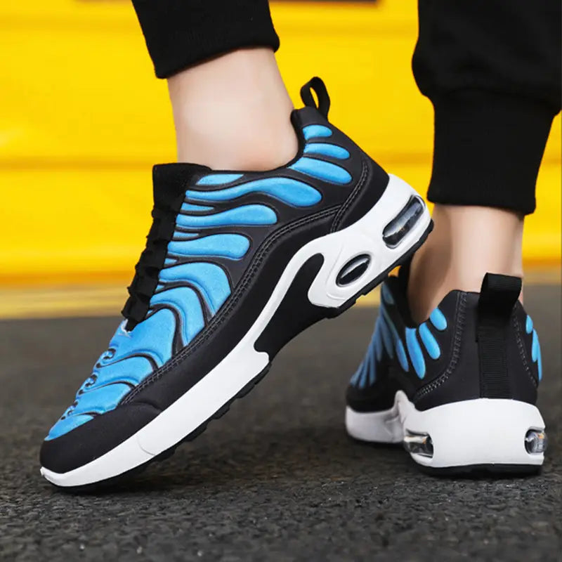 Black and bright blue air cushion running shoes with a white midsole and flame pattern fashion sneakers featuring an air cushioning unit in the heel.