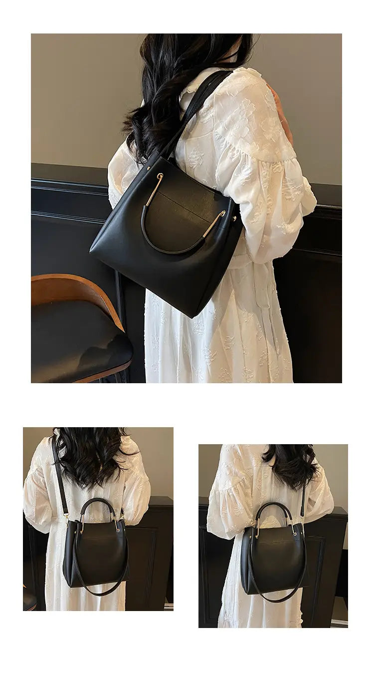 Black leather minimalist bucket bag featuring a distinctive silver metal handle accent and a detachable strap.