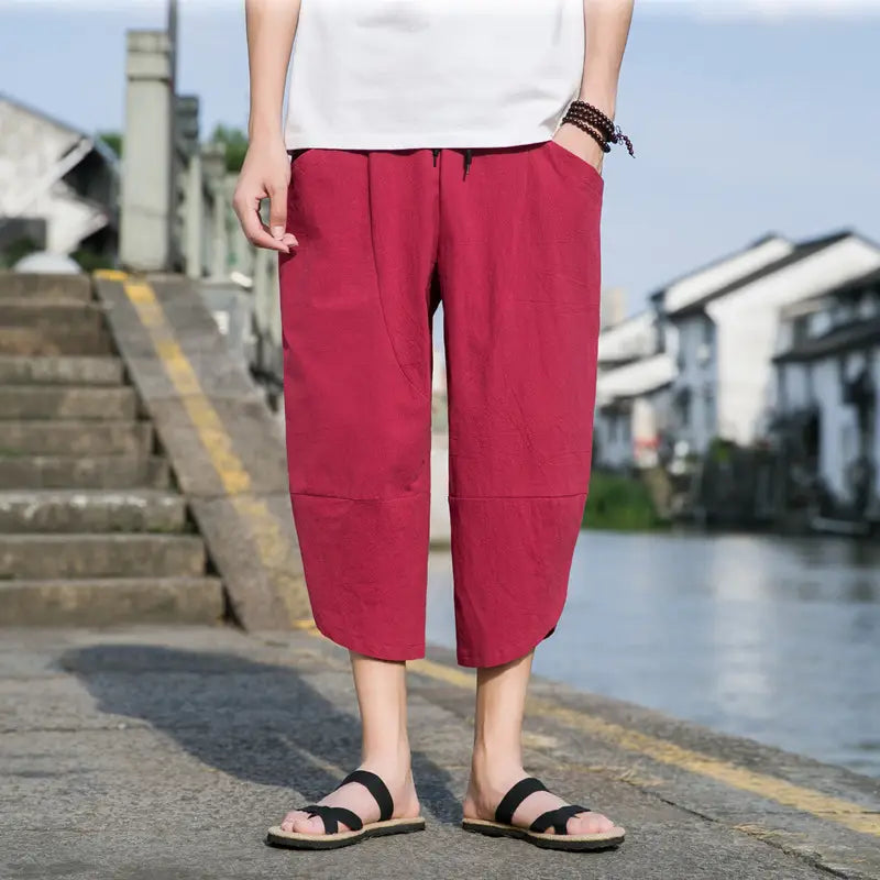 Pantalon de plage décontracté en lin pour hommes en rouge coton lin, présentant une coupe ample, longueur raccourcie, taille à cordon de serrage et poches plaquées.