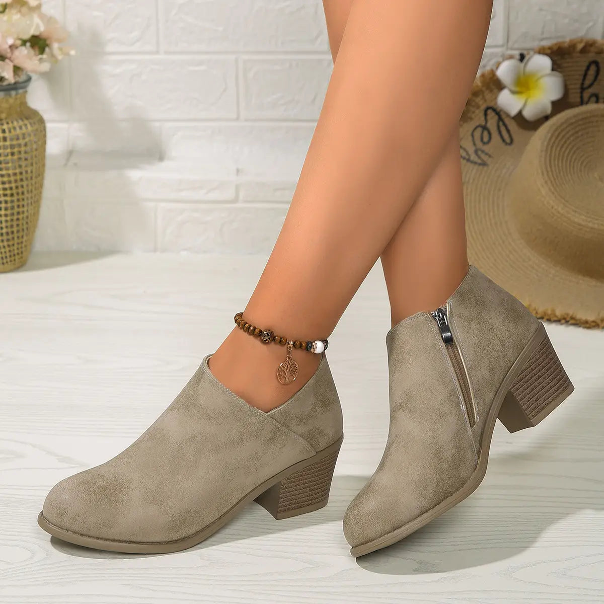 Beige suede ankle boots with a chunky block heel and side zipper for easy wear.