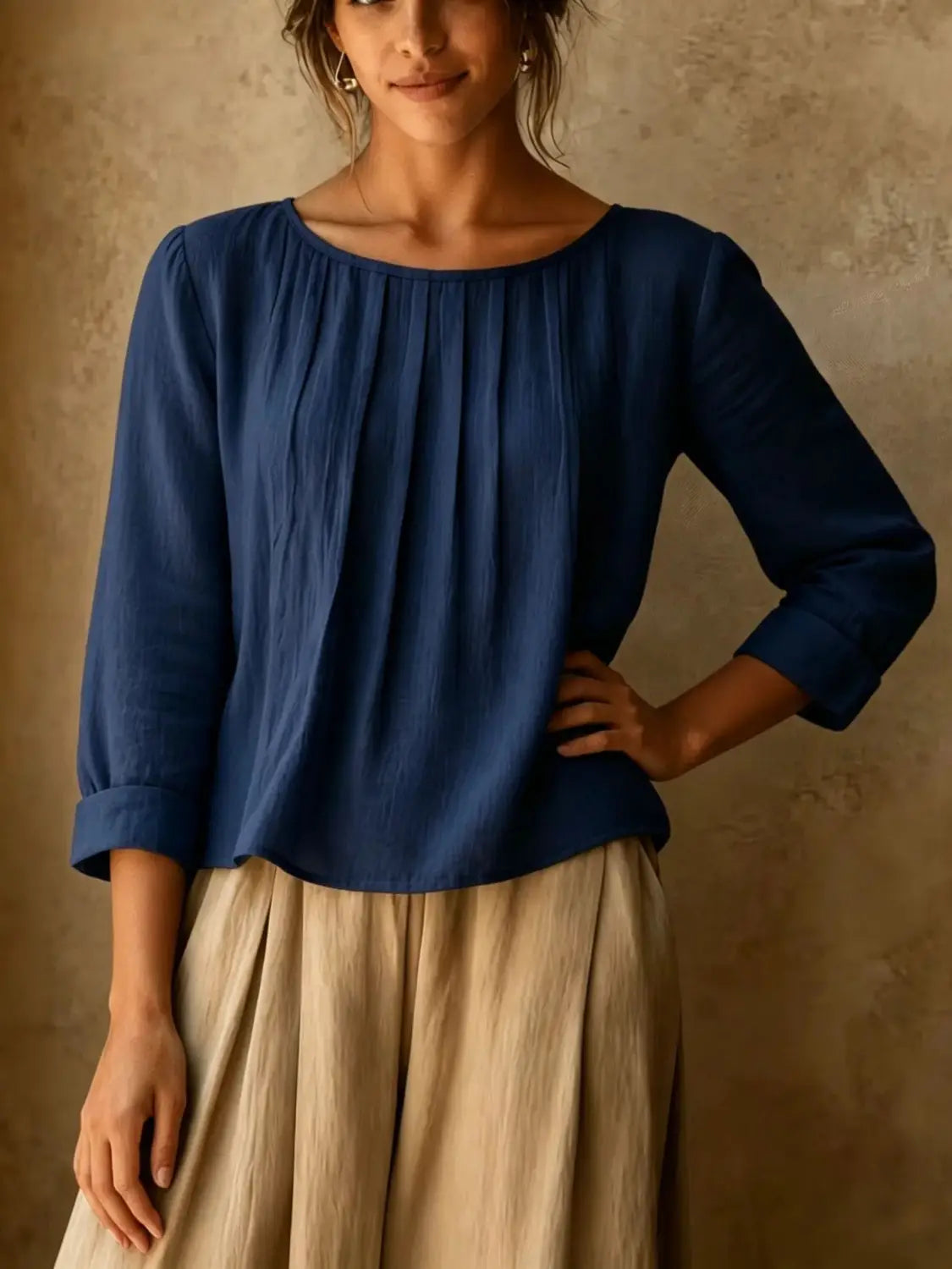 Une blouse ample en lin et coton pour femmes, bleu marine, avec de doux plis, des manches trois-quarts et des poignets retroussés.