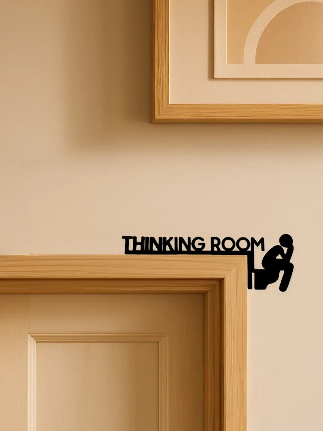 Schwarze Wandkunst aus Metall für ein Denkzimmer mit einer Silhouette eines sitzenden Denkers, gestaltet als modernes Toilettenschild.