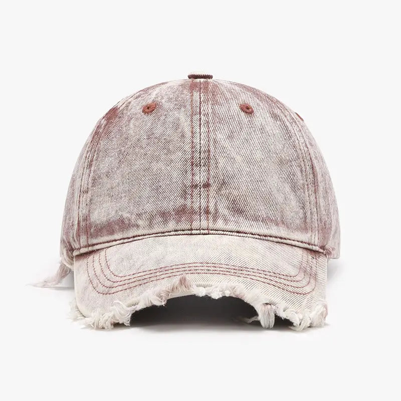 A distressed denim baseball cap with a faded washed out appearance and a frayed brim.