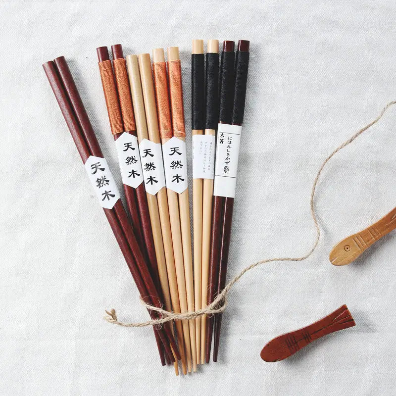 Baguettes en bois naturel avec des prises texturées aux tons de bois naturel, présentant des poignées enveloppées et une étiquetage japonais.