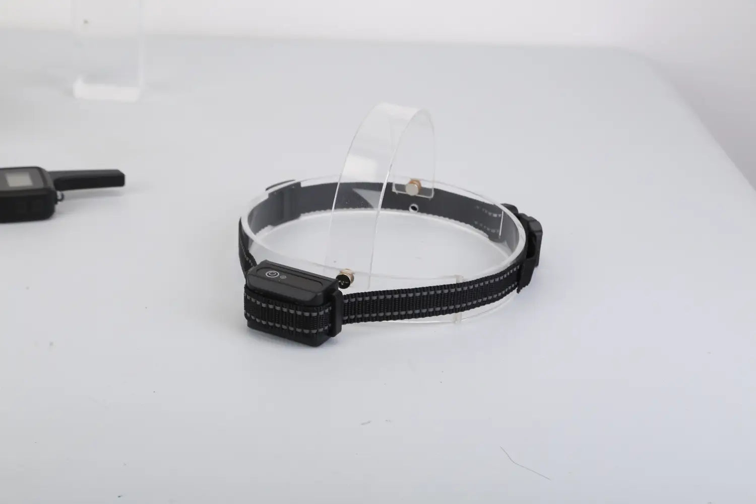 Black nylon dog training collar with transparent plastic guard and black electronic transmitter module for 3280ft waterproof shock system.