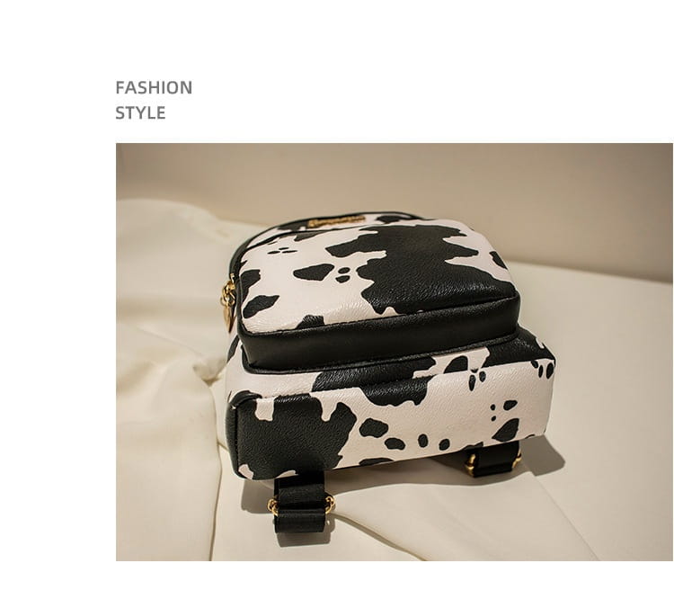 Mini backpack cow and snake print featuring black and white cow print with faux leather straps and gold-tone hardware in Korean style.
