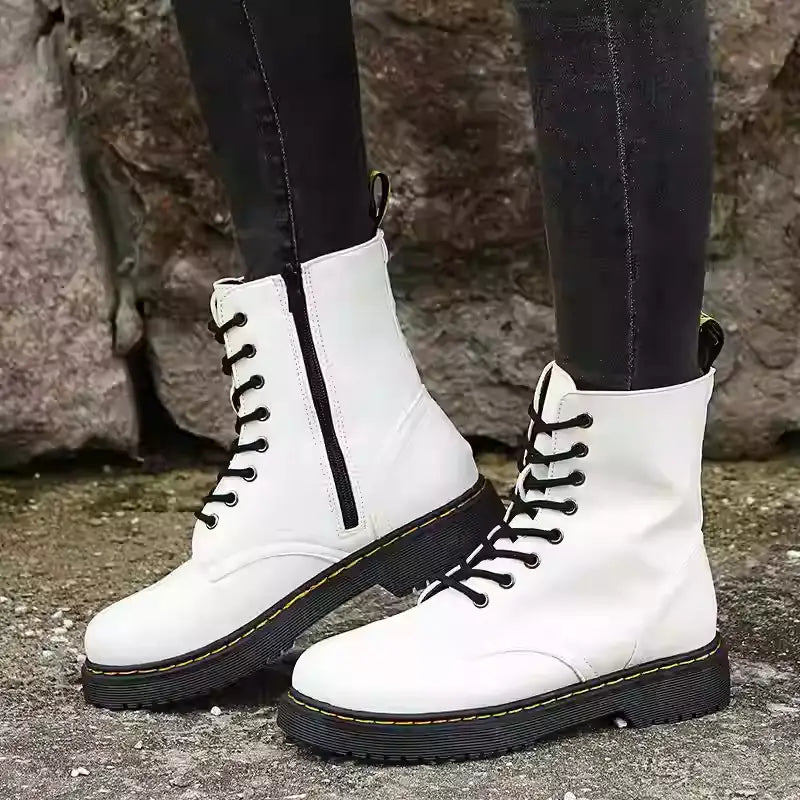Botines estilo Martin de cuero blanco con punta redonda y diseño plano a la altura del tobillo, mostrados desde el lado trasero