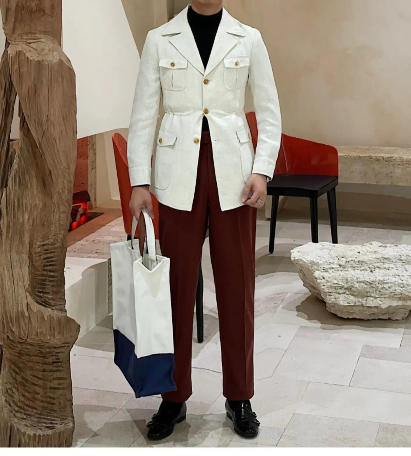 Sac cabas en toile blanc et bleu marine avec anses blanches présenté à côté d’une veste de blazer ceinturée ajustée slim fit pour homme