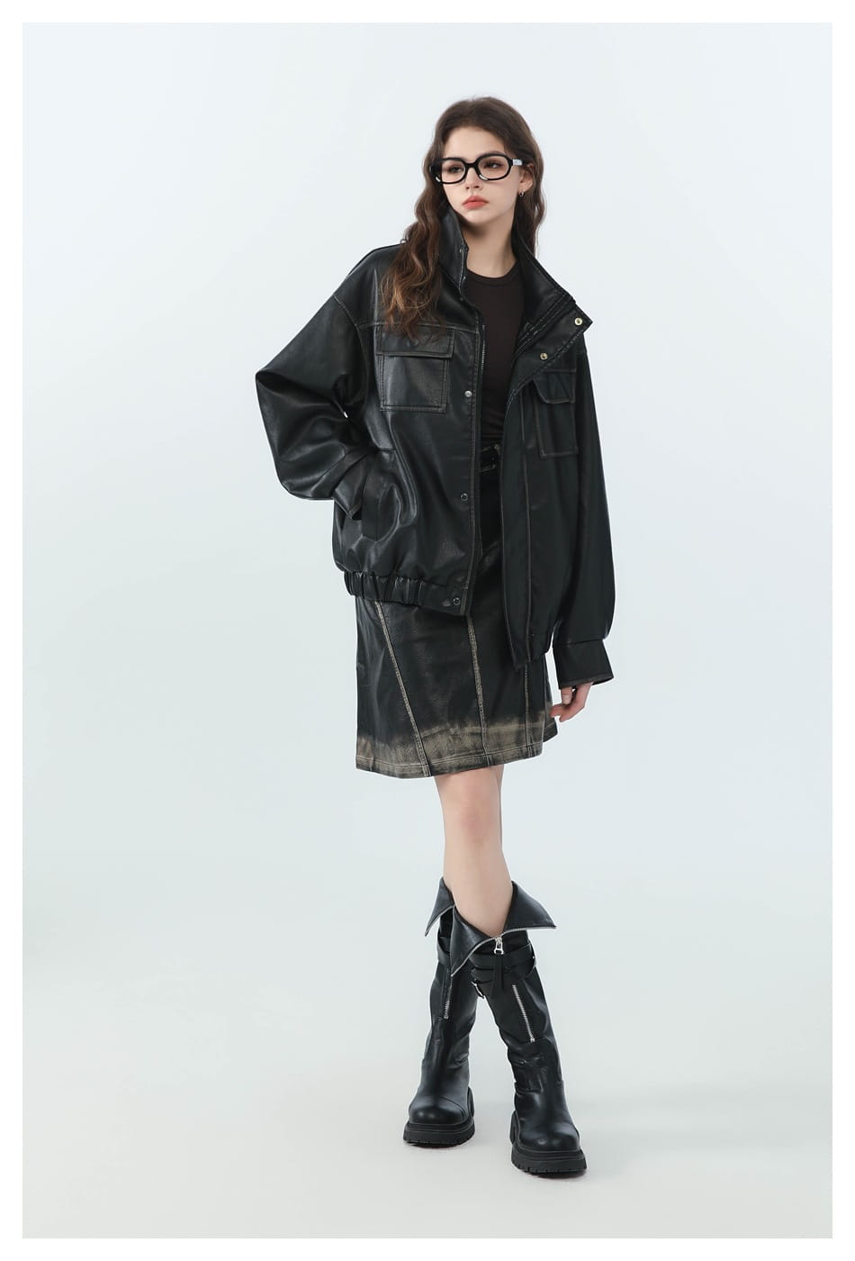 Schwarze Biker-Bomberjacke aus Kunstleder mit ausgefransten Details und Utility-Taschen mit Klappe, abgebildet von der Vorderseite.