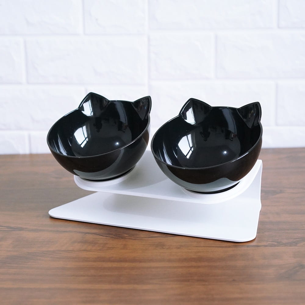 Elevated cat bowl tilted 15 degree double feeder stand with black cat-shaped ceramic pet bowls on a white stand.
