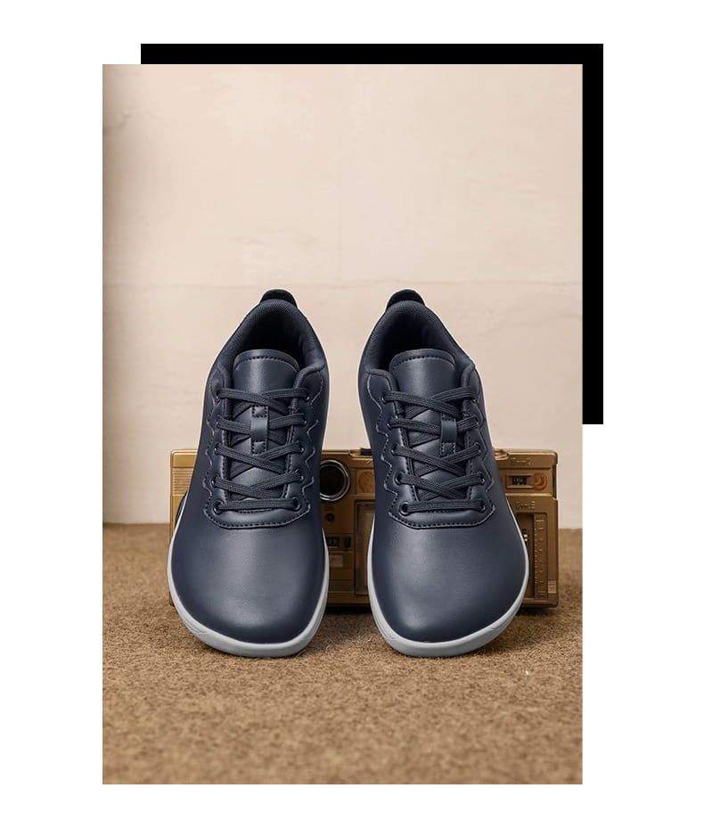 Dunkelblaue Leder-Sneaker im Low-Top-Format mit weißen Sohlen, entworfen als minimalistische Freizeitschuhe für den Outdoor-Einsatz.