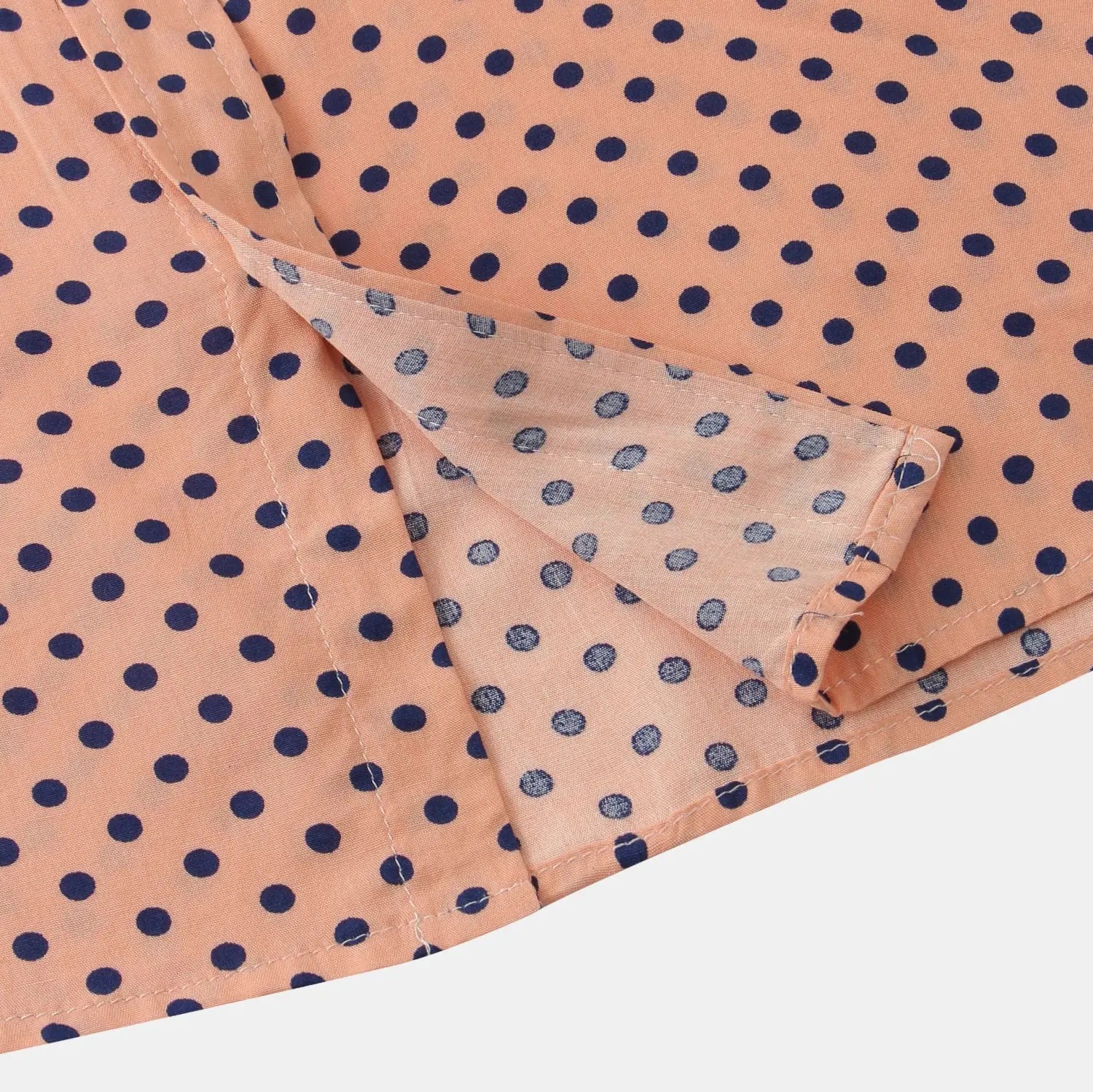 A peach-colored silk men plus size button up shirt with navy blue polka dots.