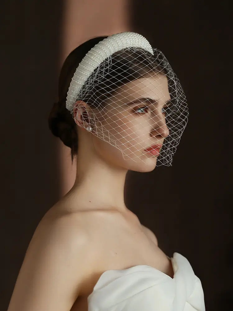 A delicate white beaded vintage French Hepburn bridal veil headband with a fine mesh veil.