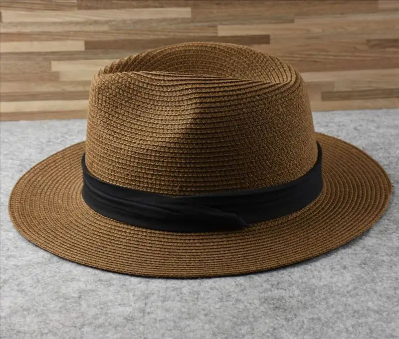 Brown woven straw fedora hat with a black satin band designed for foldable sun protection for men.
