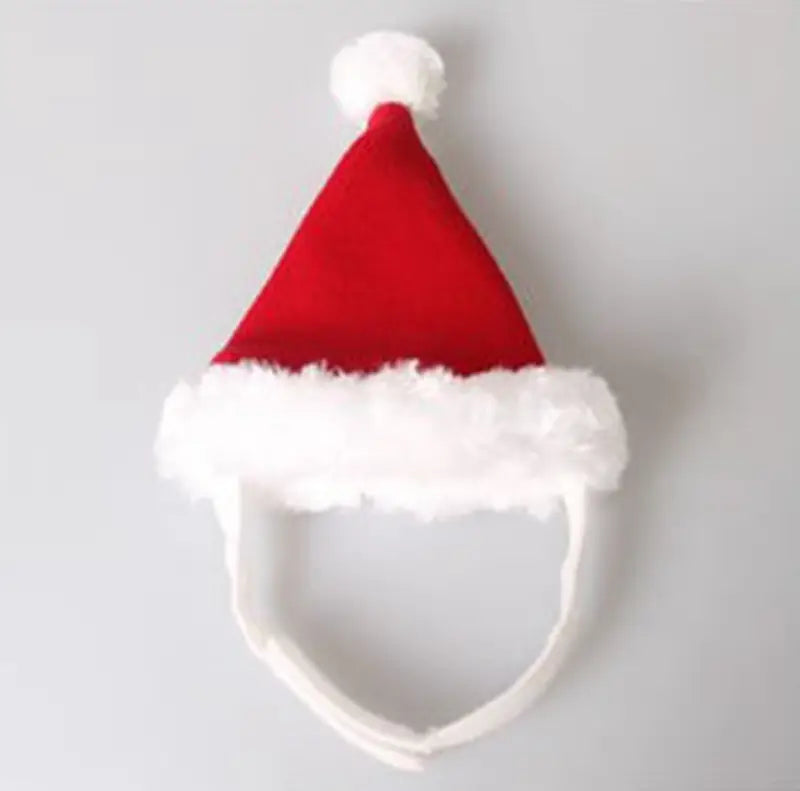 Un bonnet rouge du Père Noël avec une bordure blanche duveteuse et un pompon, conçu pour les animaux, dans le cadre d’un accessoire de bandeau de Noël avec des bois de renne pour animaux.