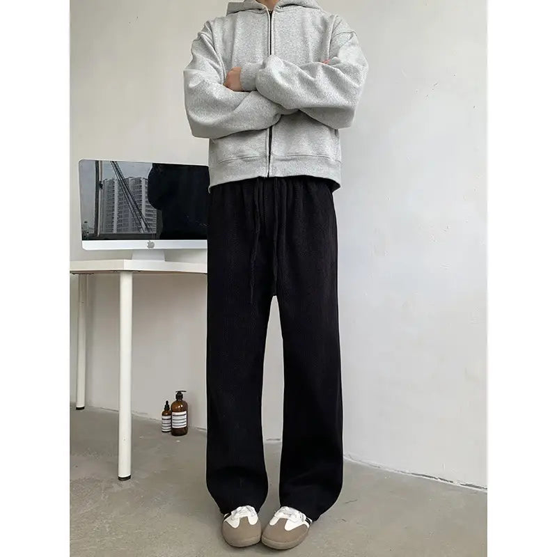 gray zip-up hoodie with a hood and front zipper made of soft fleece material paired with wide leg corduroy drawstring pants