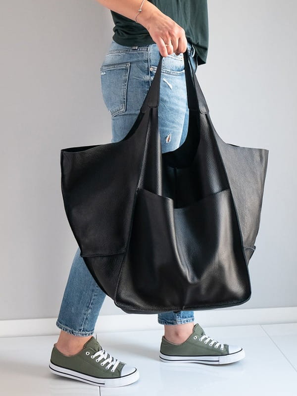 Black leather tote bag with a large capacity, soft slouchy design, and sturdy handles for shoulder use.