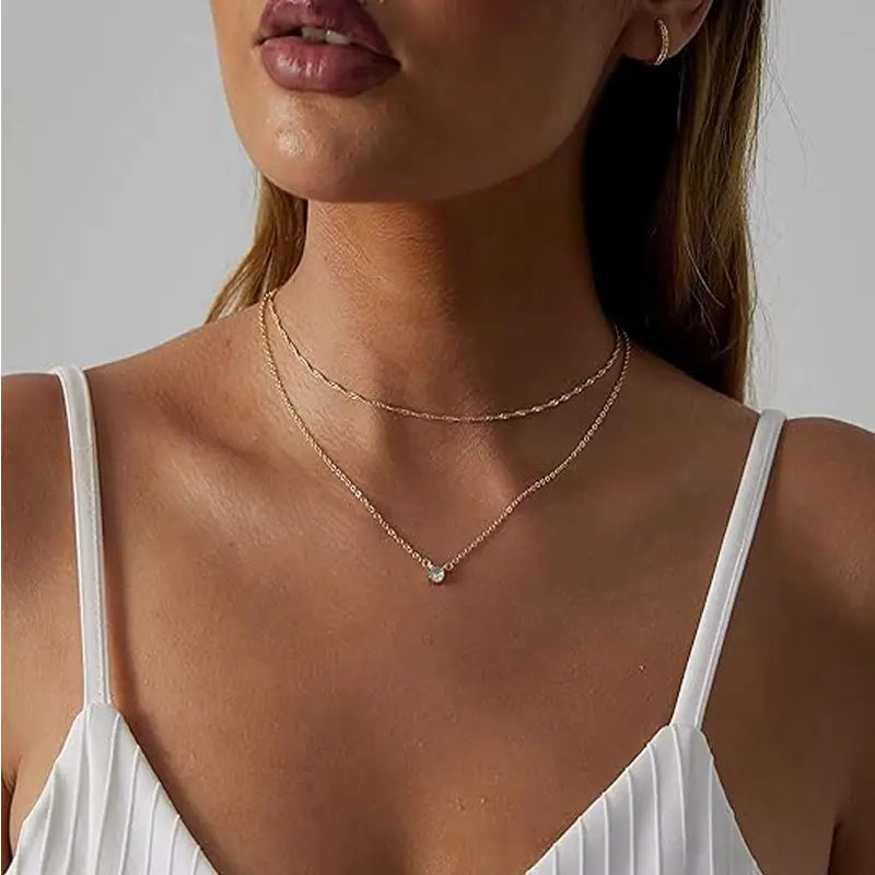 A delicate rose gold 14k gold plated dainty layered choker necklace featuring a small diamond solitaire pendant.